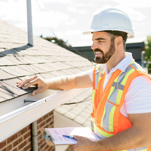 a worker in a hard hat providing a roof inspection