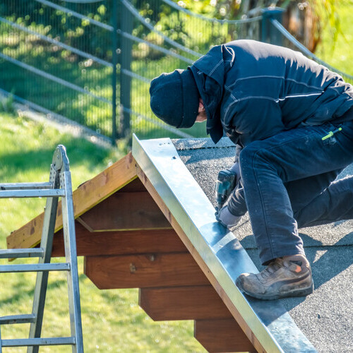 Roofer worker using battery-powered screw